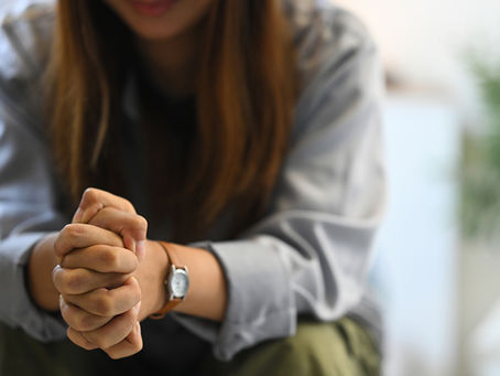 Generic image of depressed woman clasping hands.