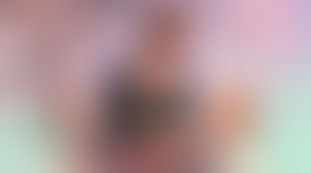 Three women in a LATAM leadership workshop: one speaks into a mic with big earrings and bun, two listen attentively. Soft pastel pinks, lavenders, mint overlays with subtle wavy cycle graphics evoke women's wellbeing and inclusive productivity.