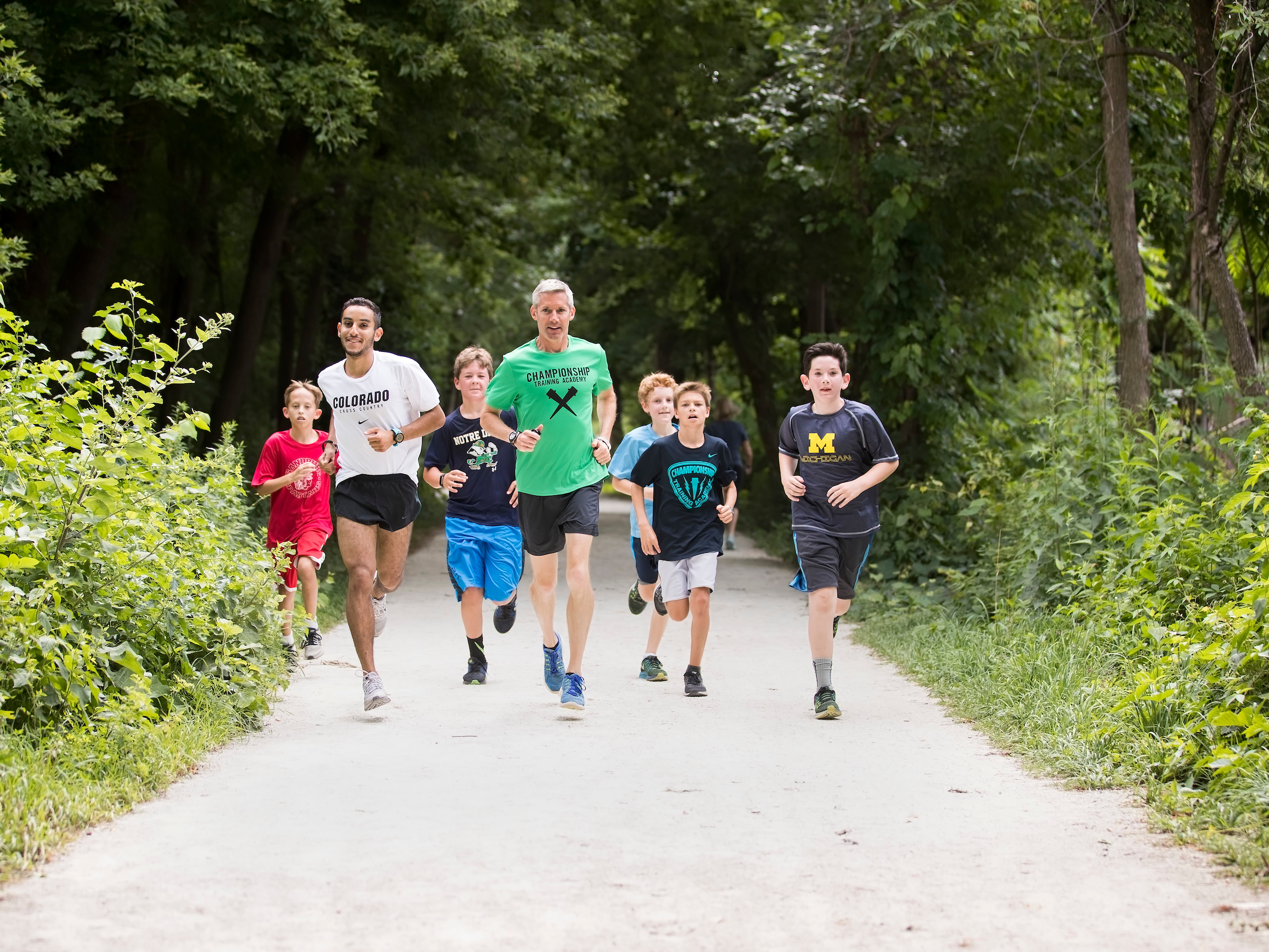 Collegiate runner Ammar Moussa running with the campers