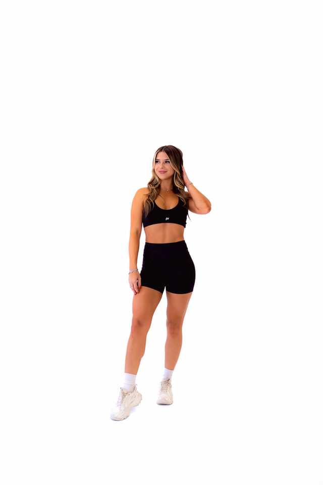 Front view of Midnight Black seamless sculpt sports bra in studio lighting