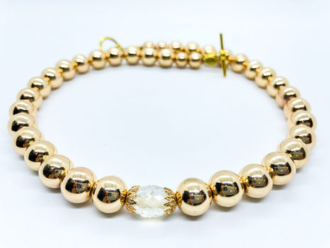 Beaded Women's Necklace made with gold beads and a crystal bead.