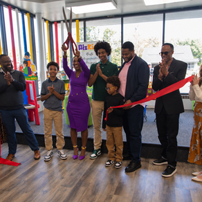 Ribbon cutting for Kidz Kingdom, with a group celebrating