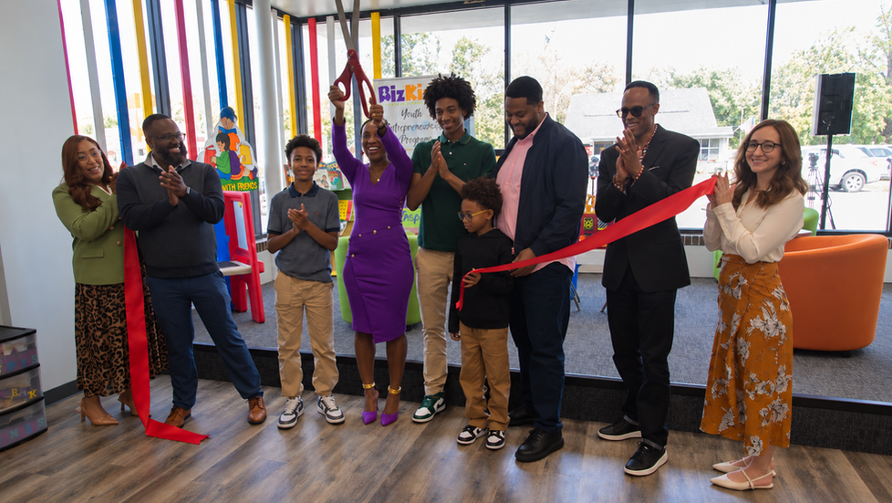 Ribbon cutting for Kidz Kingdom, with a group celebrating