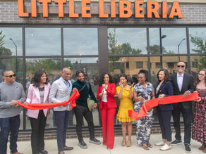 A group cutting the ribbon at Little Liberia restaurant