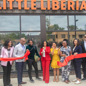 A group cutting the ribbon at Little Liberia restaurant