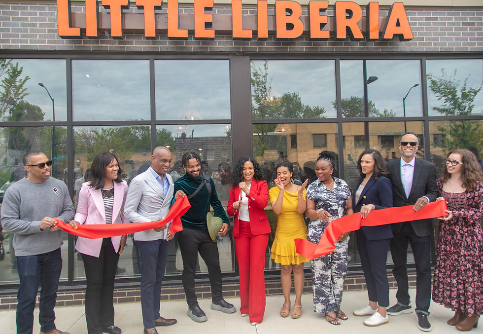 A group cutting the ribbon at Little Liberia restaurant