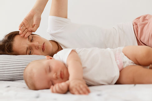 portrait-dark-haired-female-wearing-white-casual-t-shirt-lying-bed-with-little-baby-daught