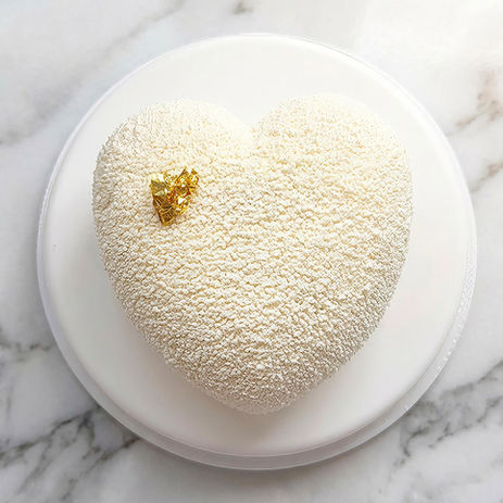 Gâteau en forme de cœur poudré blanc sur marbre.