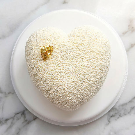Gâteau en forme de cœur poudré blanc sur marbre