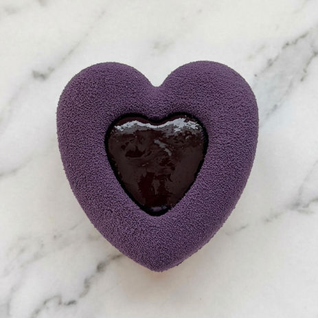 Pâtisserie en forme de cœur violet au centre chocolaté