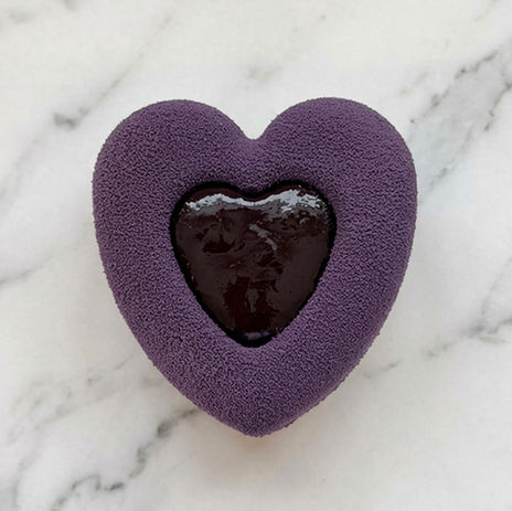 Pâtisserie en forme de cœur violet au centre chocolaté