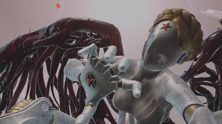Silver, star-marked android with dark red wings reaches toward camera in a game scene; subtitle reads Finally...