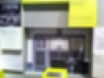 Exhibit of Ferranti computer panel with buttons and screens, surrounded by historical photos and text on yellow and white backgrounds.
