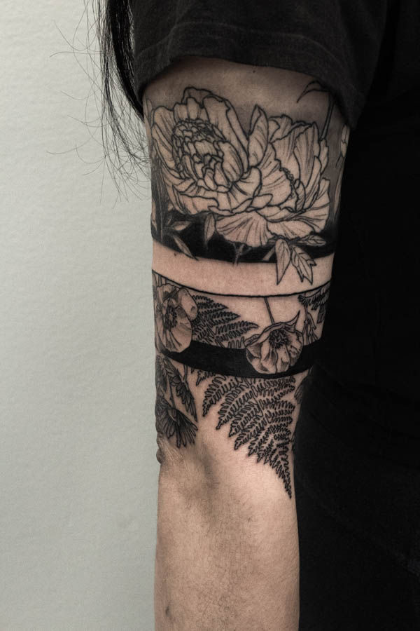 blackwork band tattoo and botanical linework elements done at out Chicago Tattoo shop