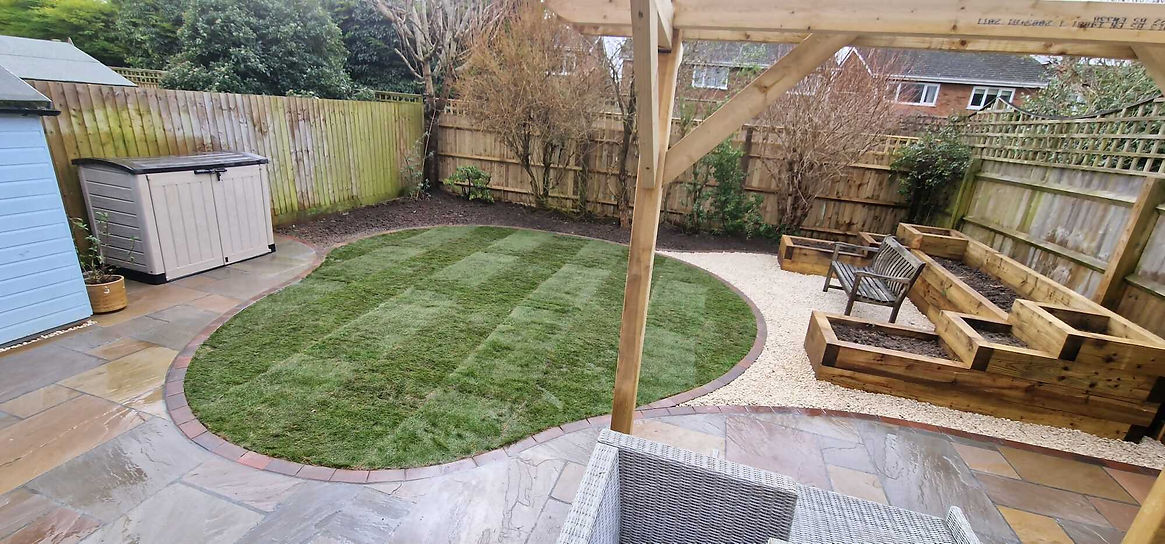 patch of grass in a garden beside a bench