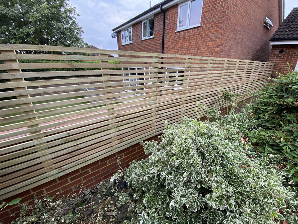 wooden fence on a brick wall dividing two houses