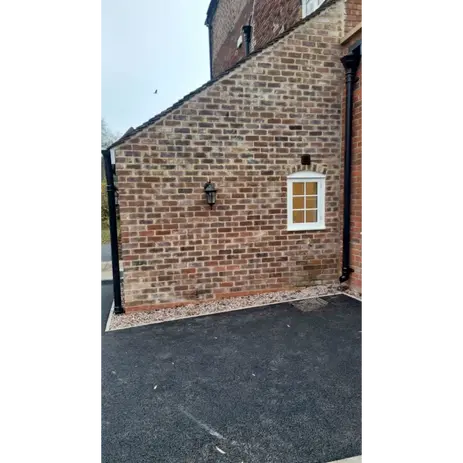 side of a farm house with a new driveway