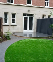 round patch of grass and path leading to glass patio doors