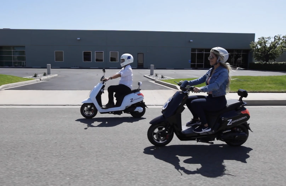 Eye-level view of a sleek electric moped parked on a city street