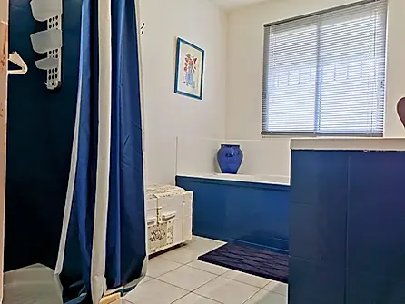 Salle de bain moderne avec carrelage clair et robinetterie chromée.