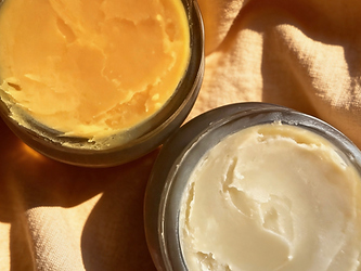 Jars with yellow and white skincare balms, part of our skincare journey.