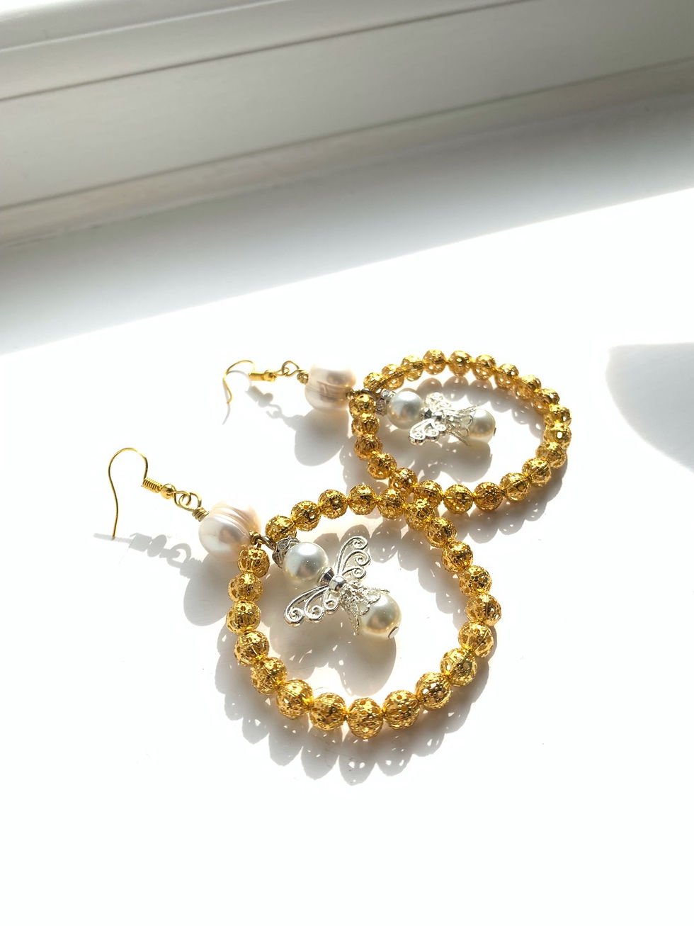Thumbnail: Statement angel gold hoop earrings with white freshwater pearl detail
