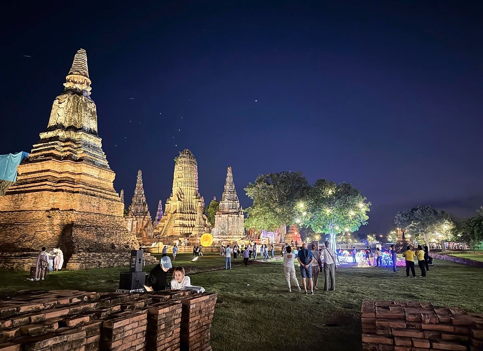 Visitors exploring illuminated historic temples in Cambodia during an evening cultural tourism experience