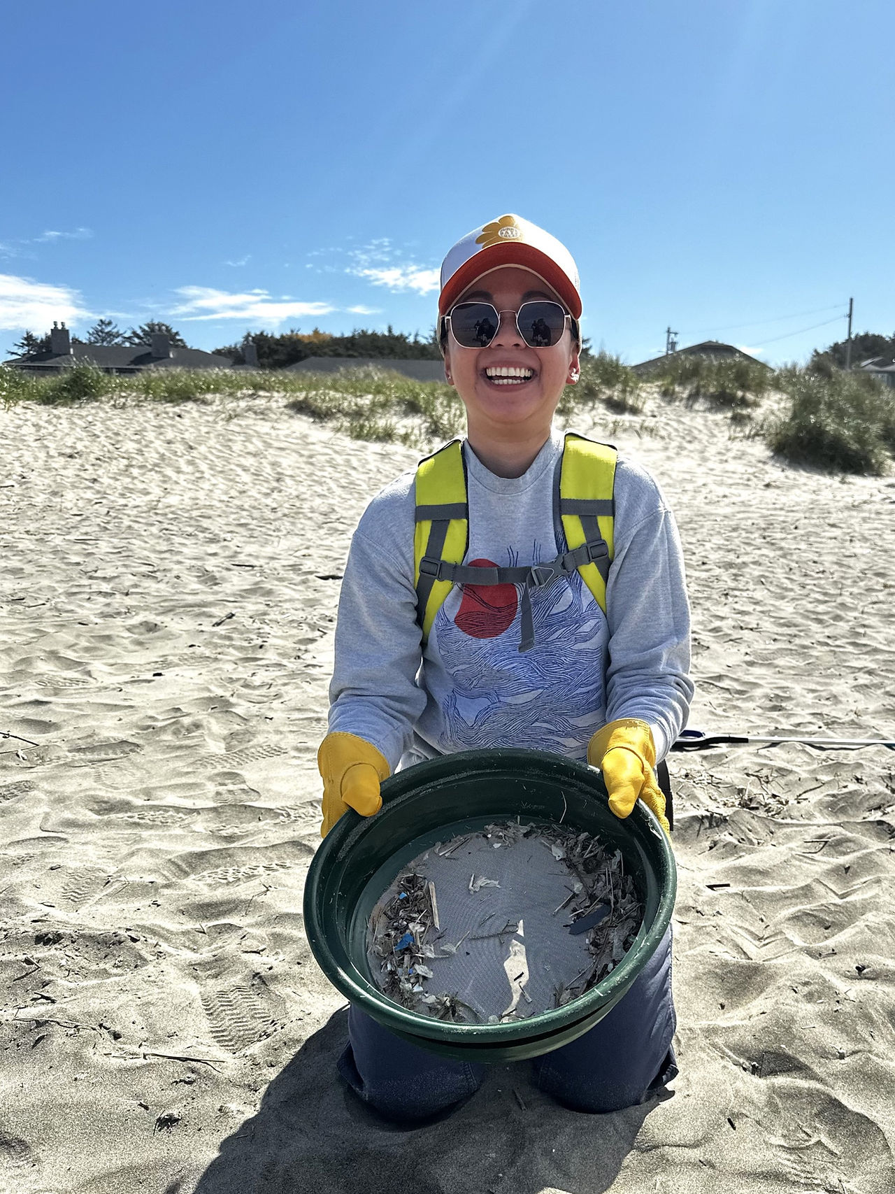 SOLVE volunteer using sifter to cleanup Oregon beach