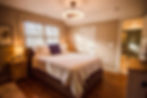 An upstairs suite bathed in afternoon light, with tailored finishes and a tiled en suite that balances refinement with everyday comfort.
