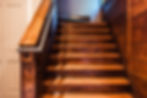 Close detail of the grand rear staircase, crafted from repurposed wood and finished with clean, modern lines.