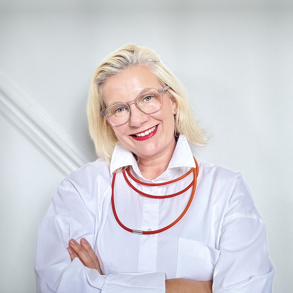 A white woman with blonde hair smiling with her arms crossed