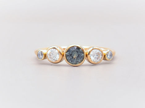 18k Yellow gold engagement ring with a blue/grey Tourmaline at the center, followed by 4 diamonds.