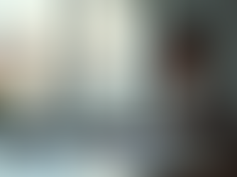 Junger Erwachsener sitzt konzentriert an einem Schreibtisch, blickt auf Laptop mit unleserlichen Zahlen und Balken, daneben Dokumente.