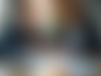 Gut gekleidetes Paar sitzt an modernem Tisch mit Laptop und Stift, vergleicht Kosten für Autonutzung (kleiner Modellwagen auf Dokumentenstapel) mit einem Abonnement (simulierte Fahrkarte), fokussiert auf ein Kostenvergleichsdiagramm auf dem Bildschirm.