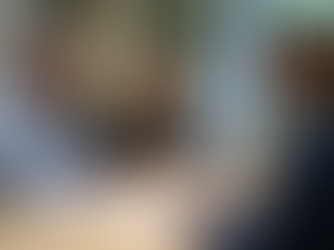 Fotorealistisches Bild: Freundliches Beratungsgespräch in modernem Büro. Schweizer Experte sitzt einem konzentrierten Paar gegenüber, Dokumente und Laptop liegen auf hellem Tisch. Fokus auf klärendem Gespräch und Unterstützung.