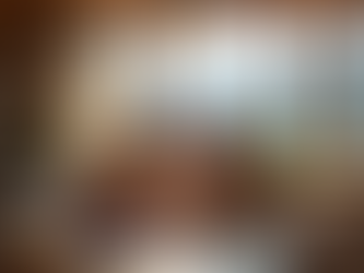 Ein Paar sitzt in einem hellen, modernen Schweizer Wohnzimmer mit Blick auf die Alpen an einem Holztisch und bespricht gemeinsam freundlich eine Hausordnung bei einer Tasse Kaffee.