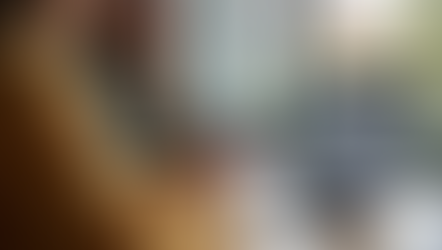 Fotorealistische Szene: Person bedient Smartphone mit Mobile-Payment-Interface am modernen Schreibtisch mit Laptop, im Hintergrund moderne Schweizer Stadtansicht.