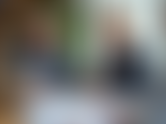 Ein Paar mittleren Alters sitzt an einem Holztisch in einem Beratungsbüro vor Dokumenten und einem Laptop mit abstrakter Benutzeroberfläche. Eine Hand deutet auf ein Dokument, Atmosphäre ist ruhig und lösungsorientiert.