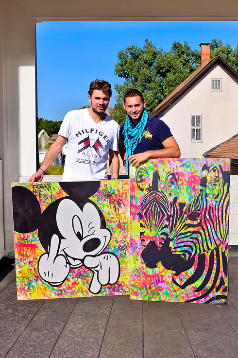 Le tennisman Stanislas Wawrinka pose aux côtés du tableau Mickey Mouse pop art de Vincent Bardou. Découvrez les œuvres de l’artiste sur sa galerie d’art en ligne officielle.