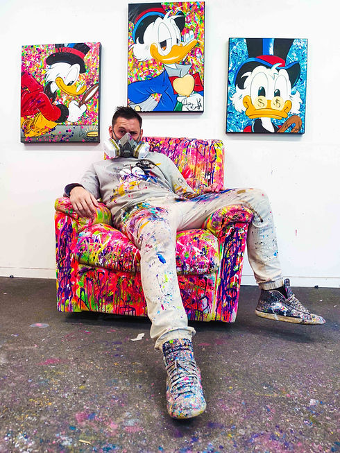 Discover an exclusive photo of the renowned street artist Vincent Bardou in his studio, surrounded by his unique creations featuring Scrooge McDuck. This behind-the-scenes glimpse showcases Bardou's distinctive style, blending street art and pop culture. Explore how Bardou's innovative use of acrylics, oils, and aerosols brings iconic characters to life. Witness the creative process of one of the most celebrated artists in contemporary art, as he transforms classic cartoon figures into striking, one-of-a-kind masterpieces.