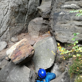 Narrow cave entrance in Saxon Switzerland, typical for adventurous cave tours