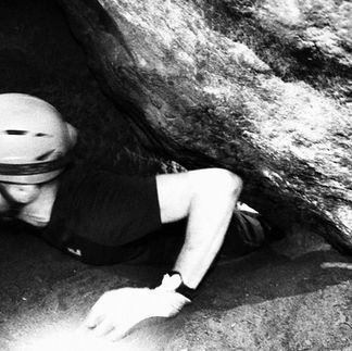 Guided cave tour in Saxon Switzerland with helmet and headlamp inside sandstone cave