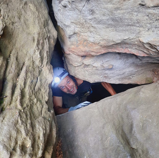Hidden cave entrance in Saxon Switzerland forest, part of a guided cave tour