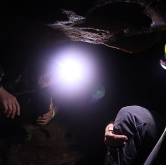 Guided cave tour in Saxon Switzerland with helmet and headlamp inside sandstone cave