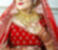 A woman in a traditional indian wedding dress touches her necklace