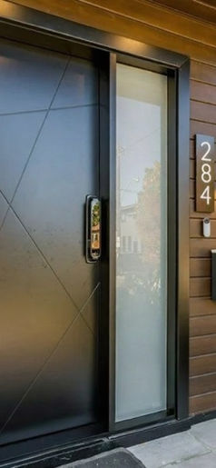 Modern entry door and wood siding detail at the completed Ellis Ave home.