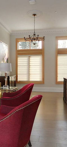 Living area with large windows and armchairs.