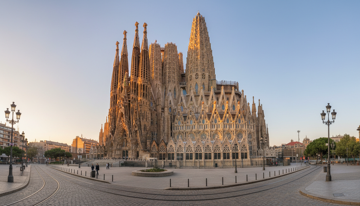 Wide-angle view of the Sagrada Família rising above Barcelona at sunrise.
