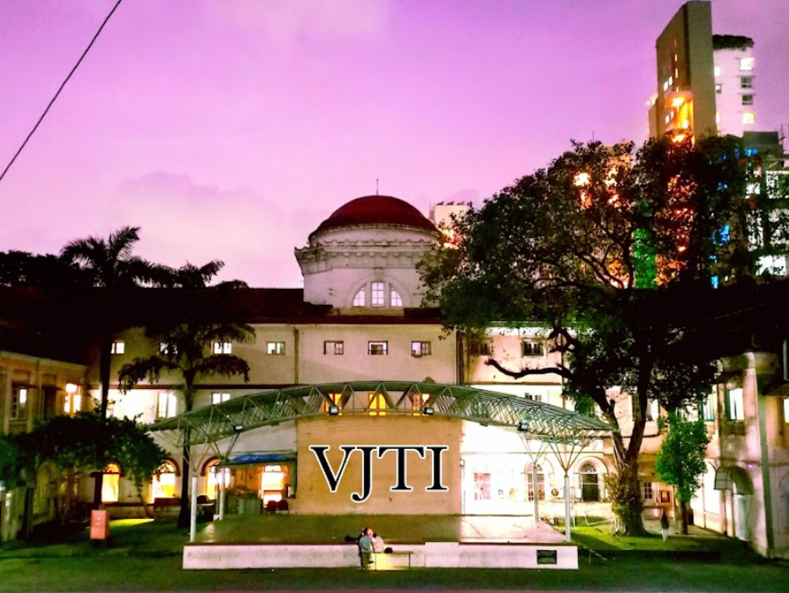 Building with a red dome under a pink sky, trees, and lit windows. "VJTI" is displayed prominently. Two people sit on a bench.
