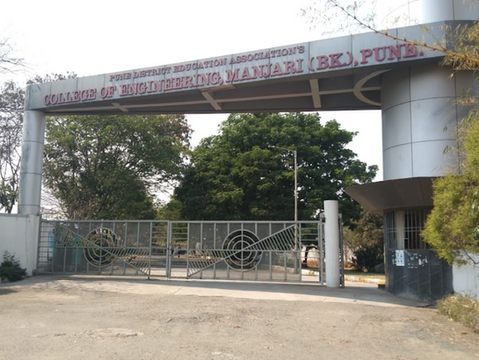 Entrance gate of College of Engineering, Manjari (Bk), Pune. Text on a metal gate, trees in the background, sunny day.